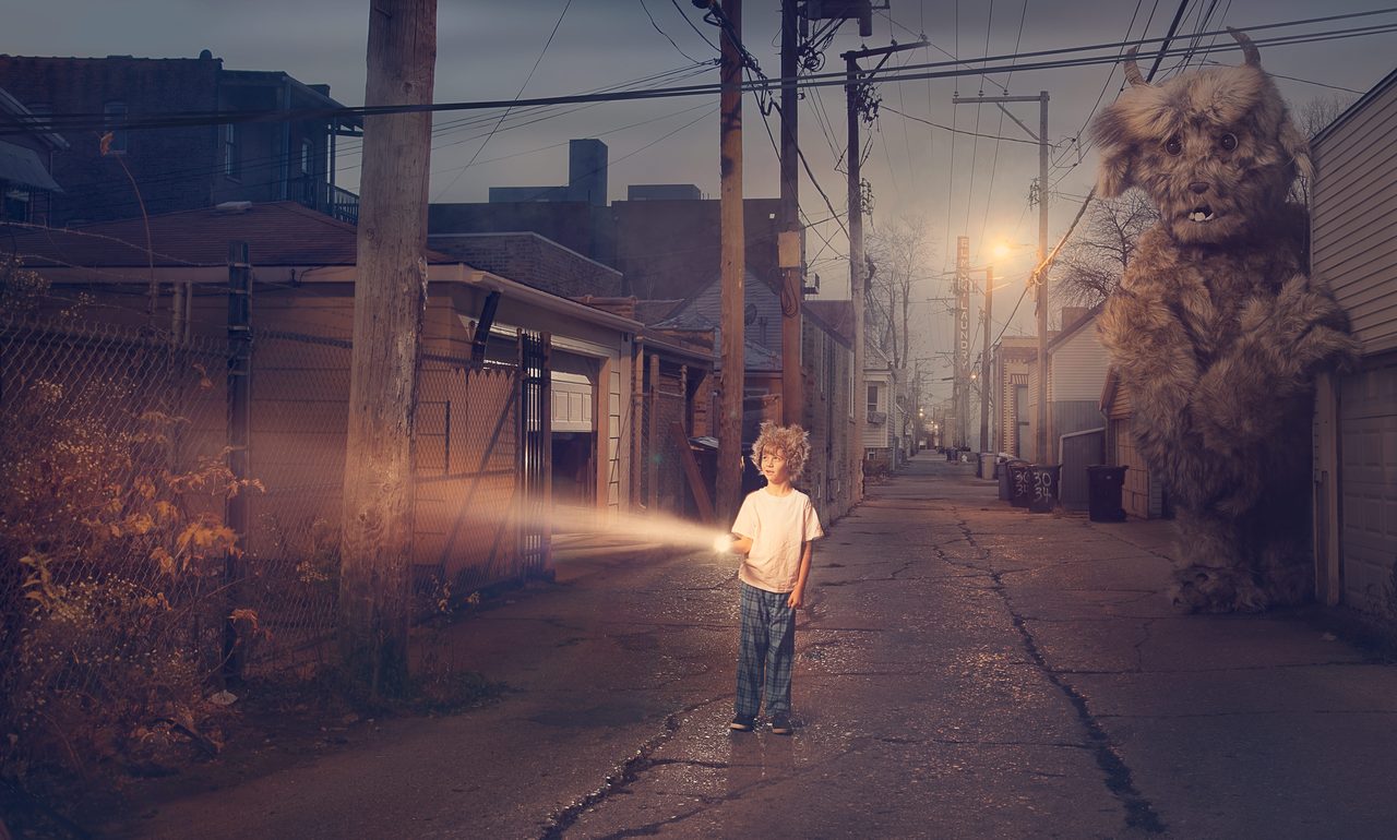 Baxter — a boy in pyjamas lights an alley with a torch while a giant furry monster waits behind him